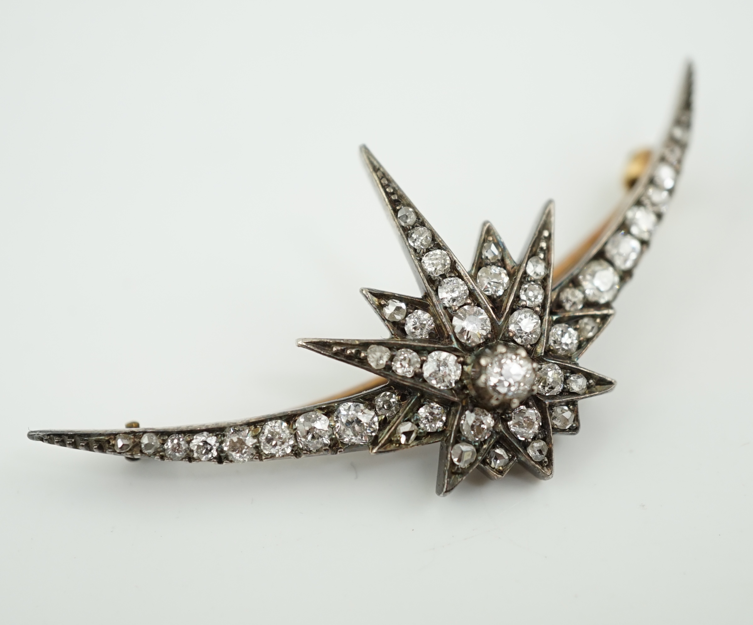 A Victorian gold, silver and graduated diamond cluster set crescent and starburst brooch
